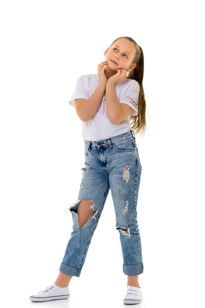 Beautiful teen girl in jeans with holes. - 写真・画像