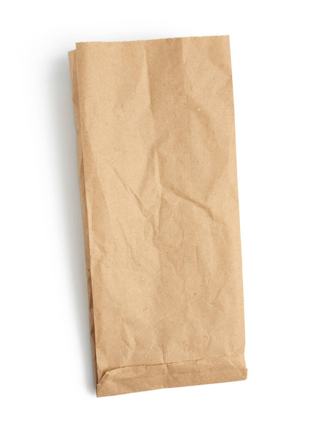 bolsa desechable de papel vacío de papel kraft marrón aislado sobre fondo blanco, concepto de rechazo de envases de plástico, plantilla para el diseñador, embalaje para la entrega de productos sin contacto, vista superior
 - Foto, Imagen
