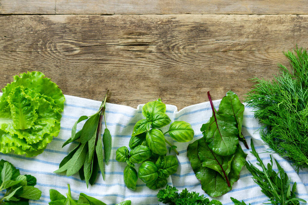 Different types of fresh herbs on old wooden background - Foto, afbeelding
