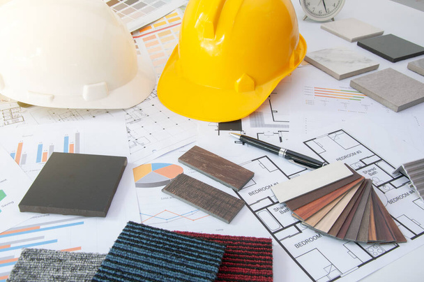 Materials construction. Home materials for Engineer and architec. Safety helmet on work table. Home budget and plan with materials design. Sample of wood laminate and carpet. - Photo, Image