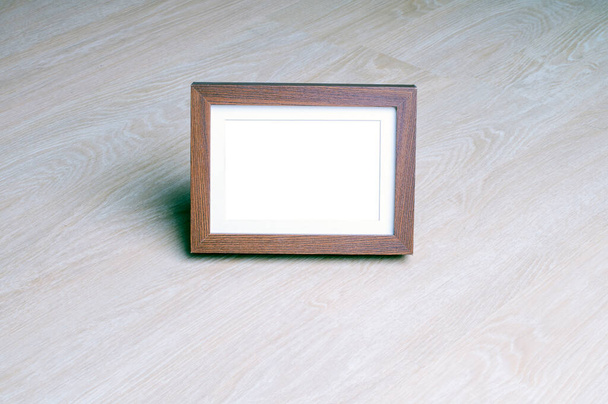 Cuadro vacío marco de madera en suelo laminado de madera. Copyspace para texto. Marco de fotos Mock up
  - Foto, imagen