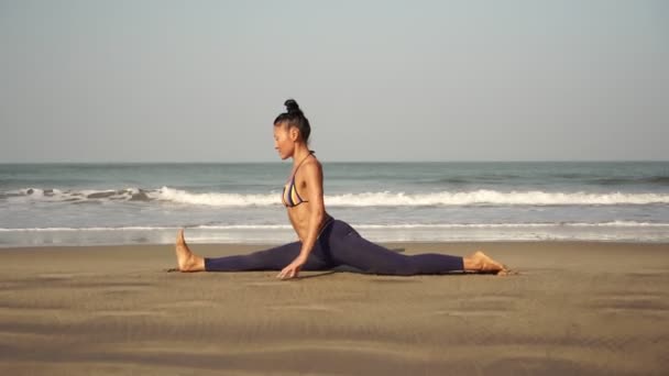 Kobieta ćwiczy jogę i siada na sznurku. Azji dziewczyna robi yoga asana - Materiał filmowy, wideo