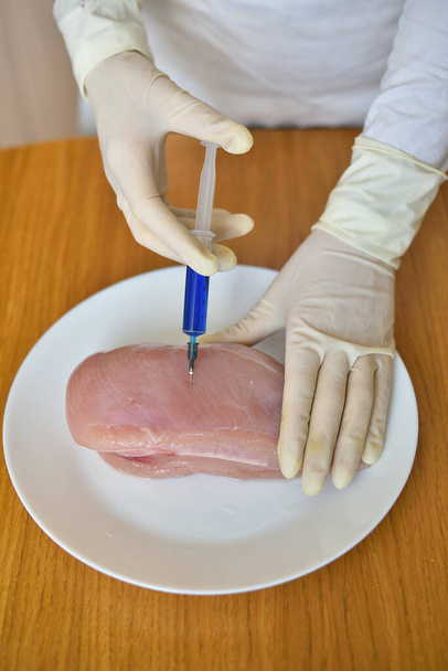 Cientista alimentar injetando frango cru
 - Foto, Imagem