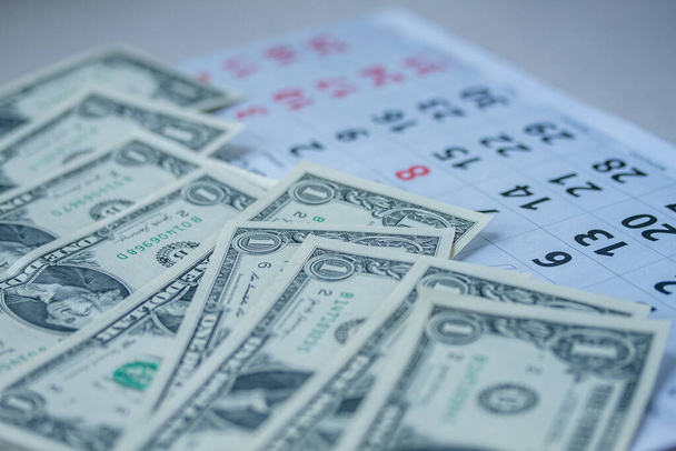 Banknotes of dollars on calendar sheets closeup  - Foto, afbeelding