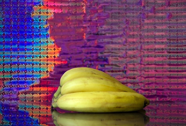 Früchte auf dem Spiegel Bananen, Kirsche, Zitrone mit farbigem Hintergrund - Foto, Bild