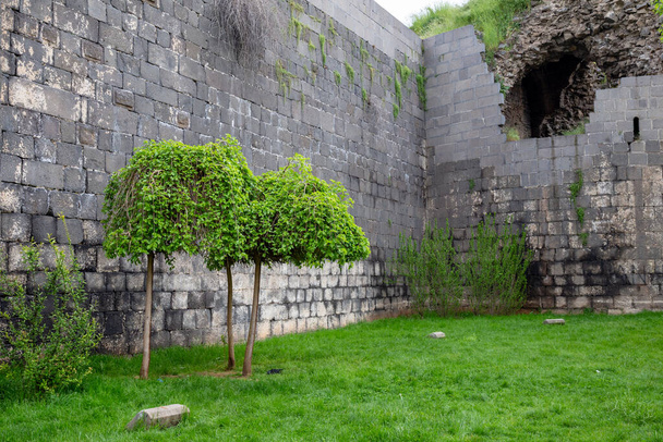 Staré městské hradby ve městě Diyarbakir, Turecko. Lidé chodí po zdech města a odpočívají.  - Fotografie, Obrázek