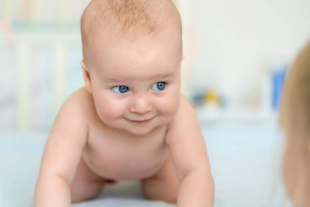 Sevimli, sevimli, beyaz, 5 aylık, bebek bebek bebek, bebek odasında karnının üstünde uzanmış, ablamla oynarken eğleniyor. Yeni doğmuş sağlıklı çocuk konsepti. Komik çocuk portresi. - Fotoğraf, Görsel