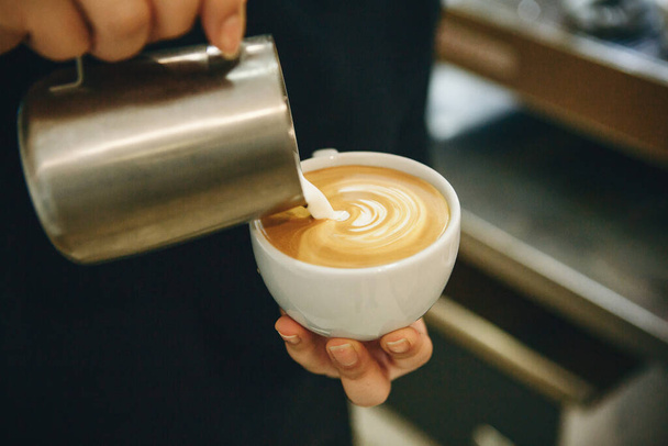 Barista pours milk into coffee - 写真・画像