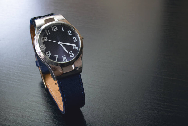 Modré hodinky na černém dřevěném stole zblízka - Fotografie, Obrázek