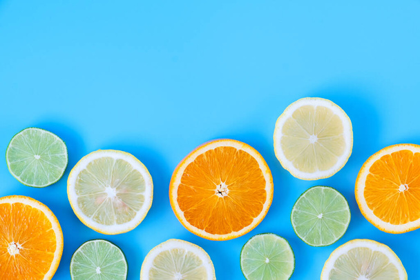 Kolekcja świeżego limonki, cytryny, pomarańczy, cytrusów, plasterka grejpfruta na niebieskim tle.  - Zdjęcie, obraz