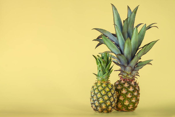 Pineapple fruit isolated on yellow background. Healthy lifestyle concept. - Фото, изображение