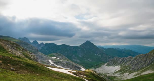 Időeltolódás, hegygerincek és csúcsok fölött mozgó felhők, vihar közeledik az Alpokon. Napnyugta fény, buja zöld völgy. - Felvétel, videó