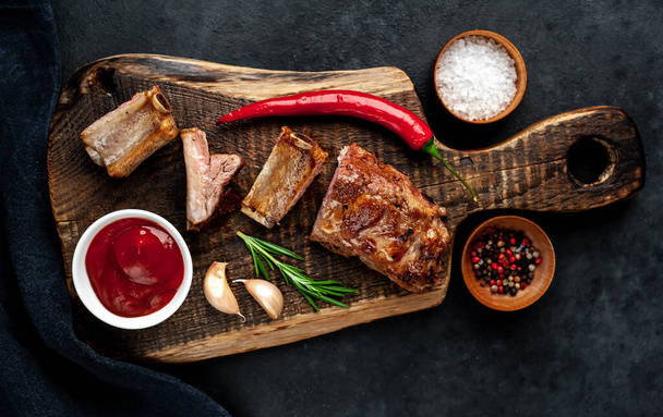 Grilled pork ribs with spices on black background - Photo, Image