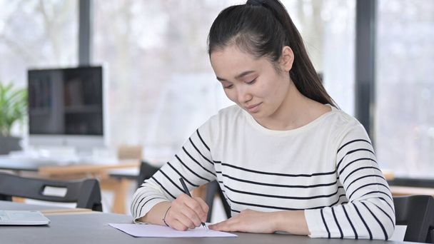 Jeune femme asiatique écriture dans le bureau - Photo, image