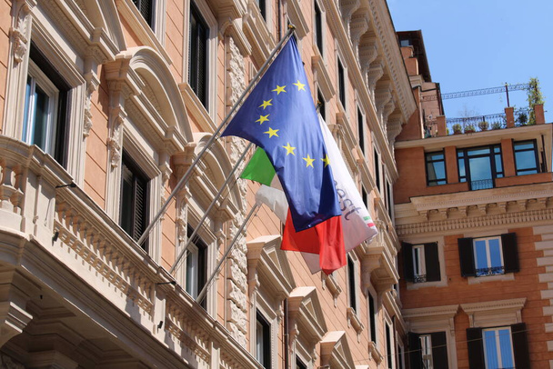 bandera italiana y banderas de la unión europea en un edificio en el centro de Roma
 - Foto, imagen