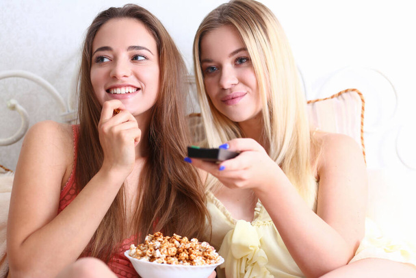 Cheerful female friends watching movie together at home - Photo, image