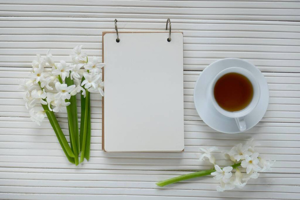 Jarní čaj.Flat lay.notebook, bílá konvice, šálek čaje - Fotografie, Obrázek