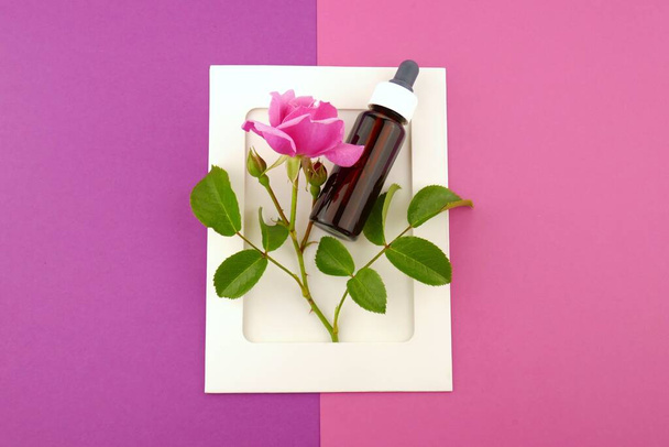 Óleo essencial de rosa.Garrafa de óleo e rosa flor
 - Foto, Imagem