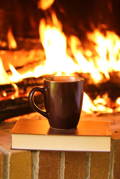 Libros en otoño. Lectura de otoño. libro y té sobre una chimenea fondo al aire libre
 - Foto, Imagen