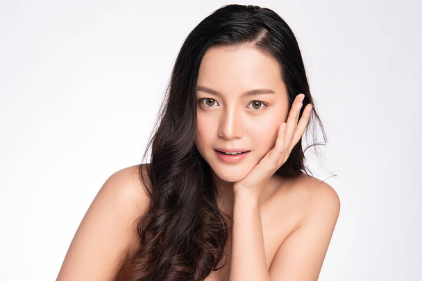 Güzel, genç Asyalı bir kadın temiz yüzüne yeni sağlıklı bir ciltle dokunuyor, beyaz arka planda izole edilmiş, Güzellik Kozmetik ve Yüz Bakımı Konsepti, - Fotoğraf, Görsel