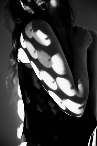 The body of nude woman with black and white pattern and its reflection. Black-and-white photo created with the projector - Foto, Imagen