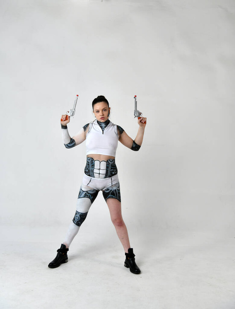 hermosa chica en robot ropa posando con revólveres de plata
 - Foto, imagen