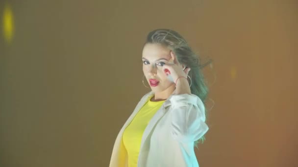 A young energetic beautiful woman looks at the camera sings dances and flirts - Imágenes, Vídeo