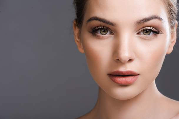beautiful young woman with makeup looking at camera isolated on grey - Zdjęcie, obraz