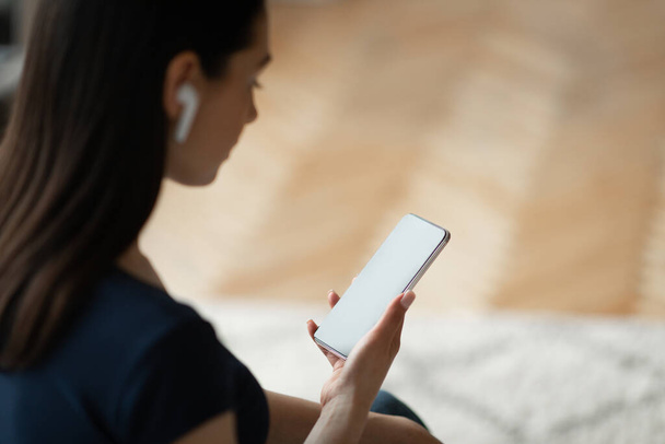 Lány fülhallgató tartja Smartphone Zenehallgatás Ül a szabadban - Fotó, kép