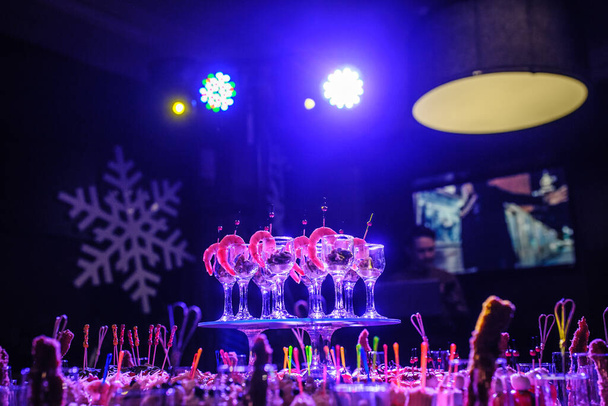 Μπουφέ τραπέζι με σνακ, καναπεδάκια? γαρίδες με σάλτσα σε γυαλιά σε ένα πάρτι γενεθλίων σε μπλε φώτα - Φωτογραφία, εικόνα