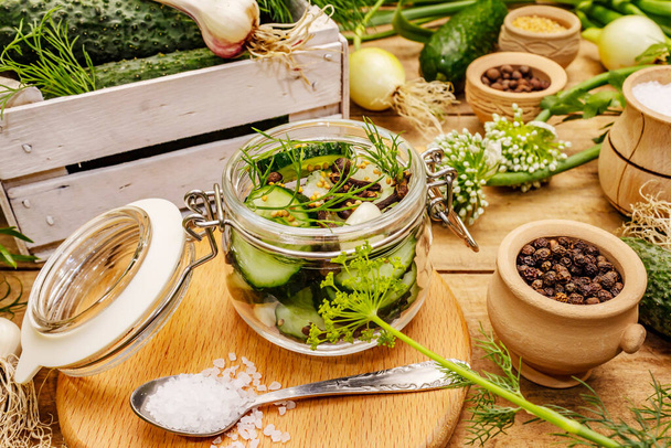 Pickling vegetables concept. Cooking process, spices, fresh fragrant herbs. Ripe cucumbers, old wooden table - Photo, Image