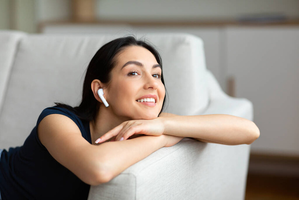 vrouw met oordopjes luisteren naar muziek ontspannen thuis - Foto, afbeelding