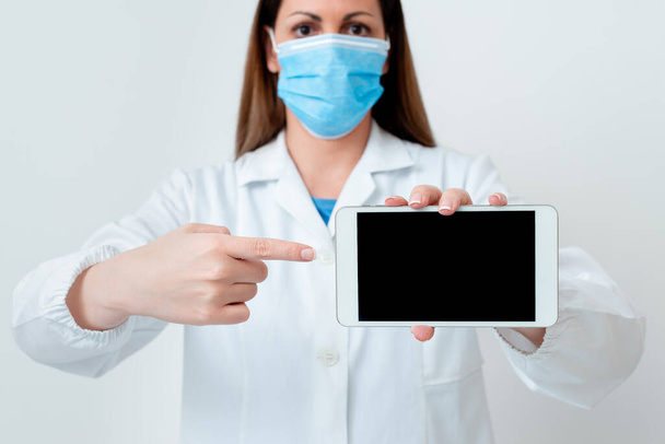 Persona que usa guantes de bata médica máscara quirúrgica diferentes tiros de ángulo tomadas con accesorios de papel adhesivo vacío Smartphone moderno
 - Foto, imagen