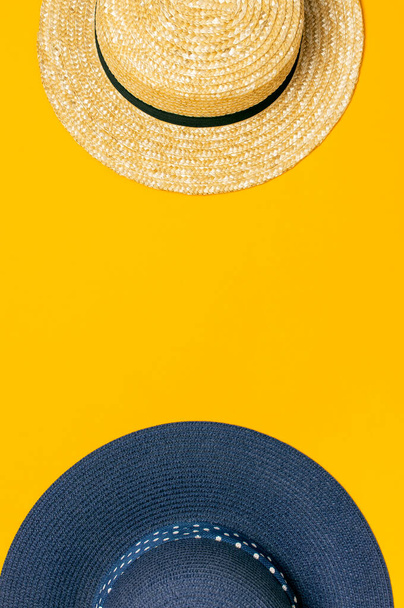 Women s summer straw hat and blue hat on yellow background top view flat lay copy space. Summer travel vacation concept, single item. Female accessory, summer background. Sea sun vacation beach. - Valokuva, kuva