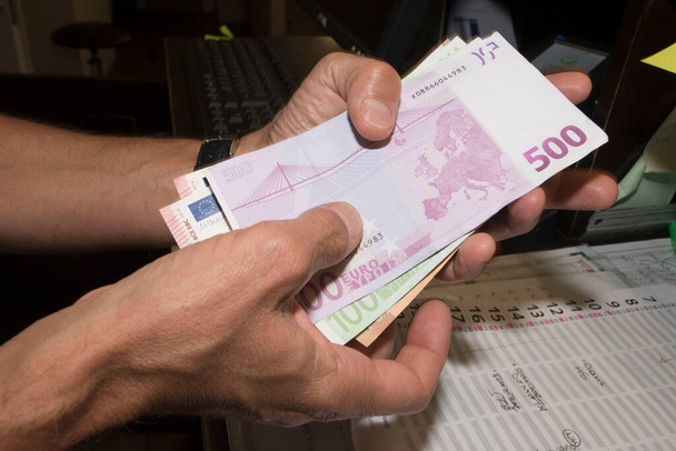 due mani in possesso di un mazzo di banconote in euro, conteggio manuale dei soldi - Foto, immagini
