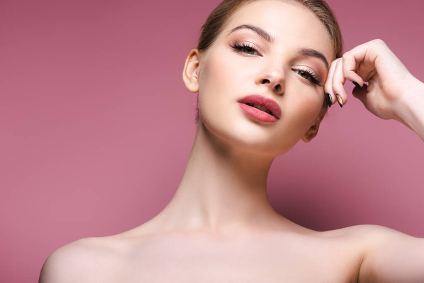 naked and young woman with makeup looking at camera on pink  - Foto, Bild