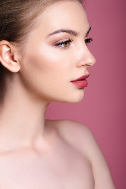 nude and young woman with makeup looking away on pink  - Fotografie, Obrázek