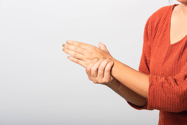 Close up hand of Asian woman she holding her acute pain in wrist of hands, studio shot isolated on white background, Healthcare medicine arthritis body care symptomatic office syndrome concept - Photo, image