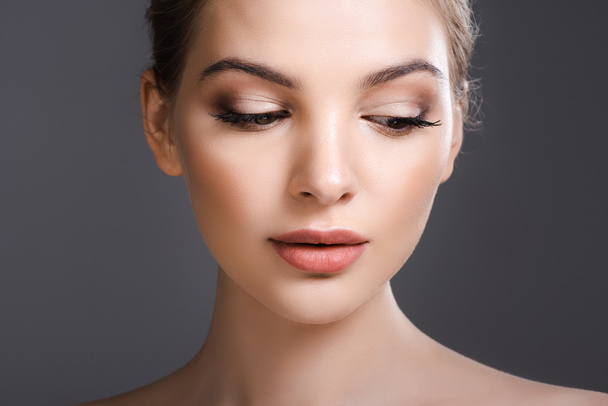 beautiful woman with makeup looking down isolated on grey  - Foto, Imagen