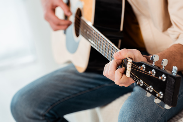 обрезанный вид человека, играющего на акустической гитаре  - Фото, изображение