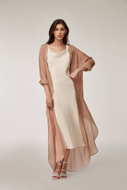 Beautiful woman fashion model makeup brunette hair perfect body shape tanned skin wear clothes summer collection organic silk dress and long shirt cape stylish sandals shoes, accessory romantic. - Foto, Bild