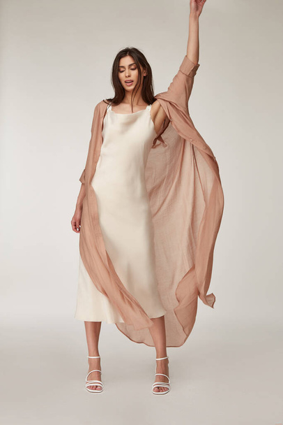 Beautiful woman fashion model makeup brunette hair perfect body shape tanned skin wear clothes summer collection organic silk dress and long shirt cape stylish sandals shoes, accessory romantic. - 写真・画像