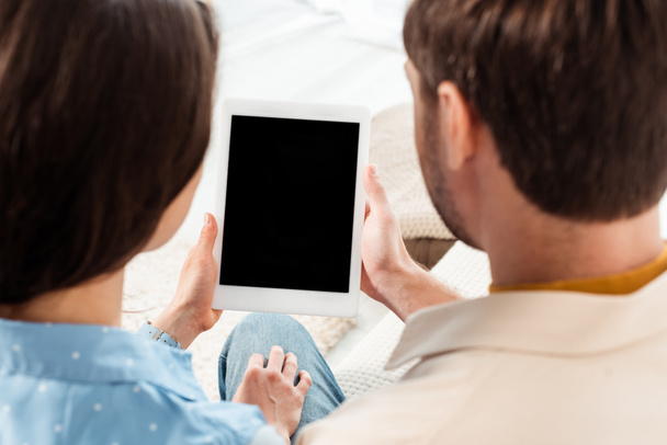 Vista posteriore della giovane coppia con tablet digitale con schermo vuoto  - Foto, immagini