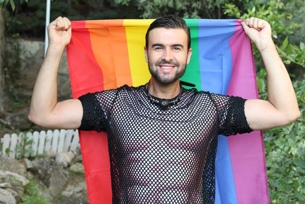 κοντινό πορτραίτο ενός όμορφου νεαρού άνδρα με στολή γκέι με σημαία lgbt στο δρόμο - Φωτογραφία, εικόνα