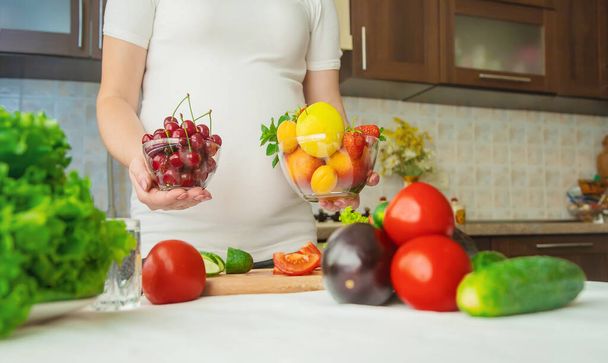 Uma mulher grávida come legumes e frutas. Foco seletivo. Alimentos
. - Foto, Imagem