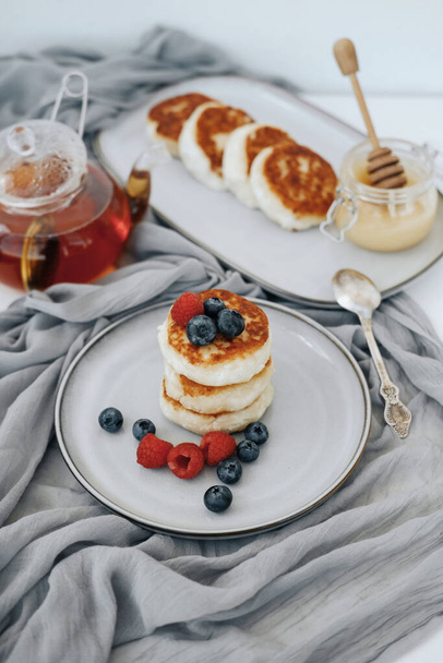 Tasty curd cheesecakes with berries on a plate - Photo, image