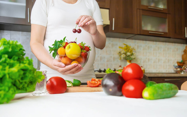 妊婦は野菜や果物を食べる。選択的フォーカス。食べ物. - 写真・画像