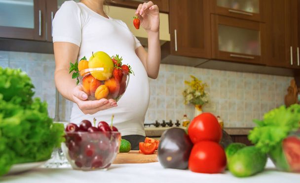 妊婦は野菜や果物を食べる。選択的フォーカス。食べ物. - 写真・画像