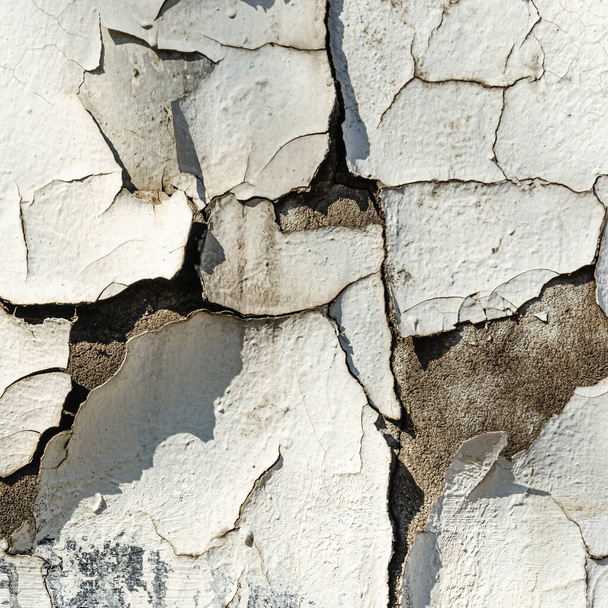 Old plaster wall surface. Abstract textured background. Deep cracks on a white wall. Closeup - Photo, Image