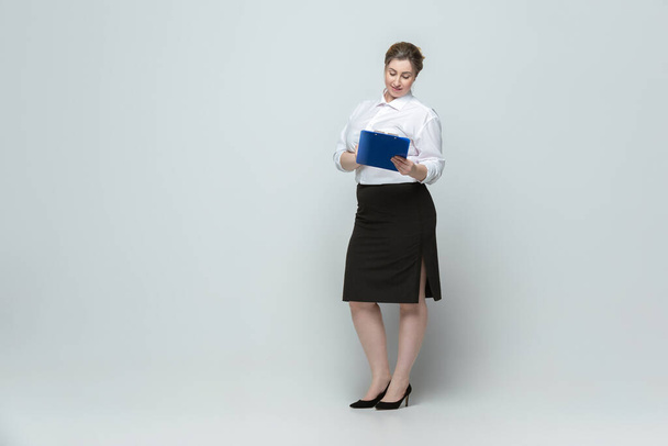 Young caucasian woman in office attire on gray background. Bodypositive female character. plus size businesswoman - Φωτογραφία, εικόνα